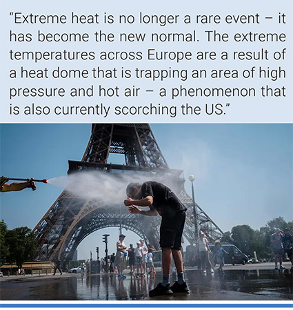 A municipal employee pours water on a tourist at the Eiffel Tower. Photo: AFP.